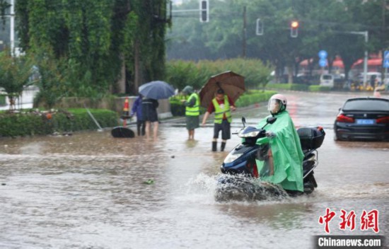 5月10日，广西沿海遭遇强降雨。图为钦州市民众在积涝中出行。陆敏  摄
